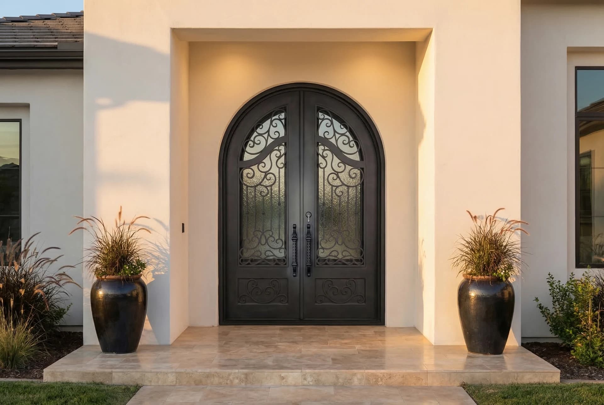 Modern arched iron door in warm stucco entry